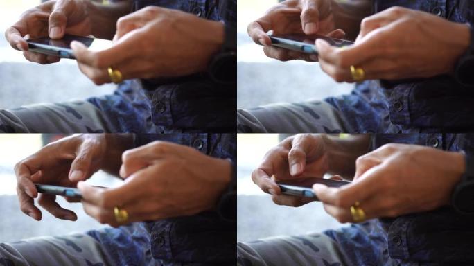 男人的特写镜头使用智能手机玩游戏娱乐。