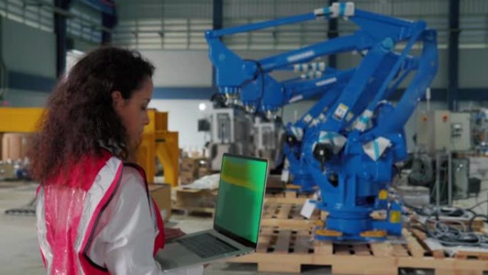 团队工程师在自动化工厂使用平板电脑编程工业机器人