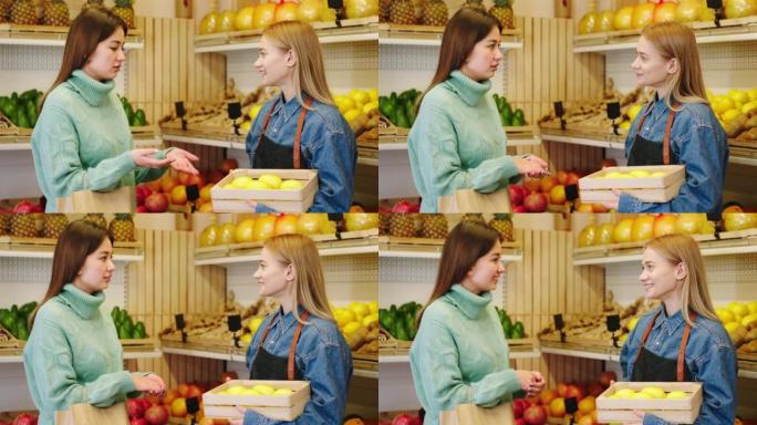 在有机蔬菜商店里，农夫女士与顾客农夫女士交谈，她拿着一个装有成熟柠檬水果的盒子