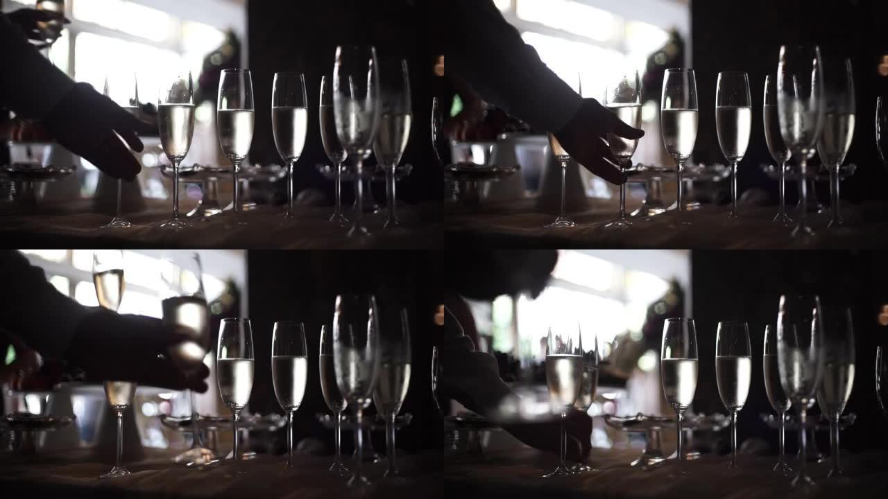 一只男性和女性的手从桌子上拿了一杯香槟的特写镜头。特写嘉宾拿杯香槟。人们戴眼镜