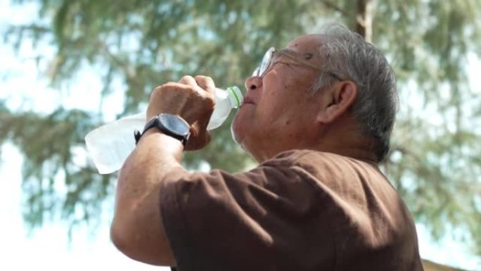 快乐的亚洲老年老年人在海滩上户外喝水玩得开心暑假享受自由人们周末的生活方式活动理念。