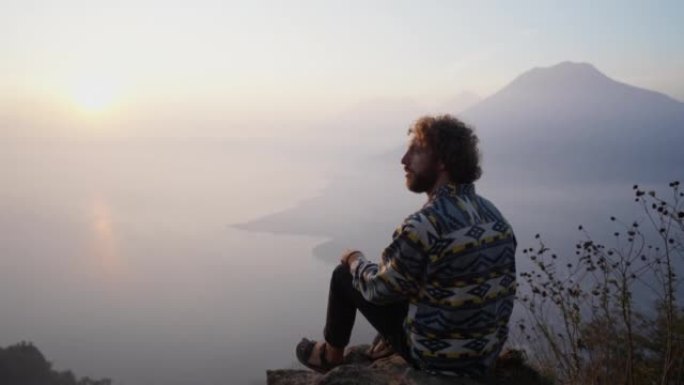 日落时分，坐在危地马拉阿蒂特兰湖背景上的人
