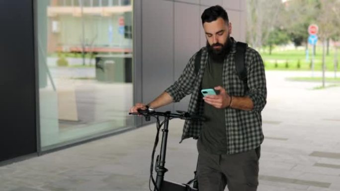 通勤者在使用手机时推电动自行车