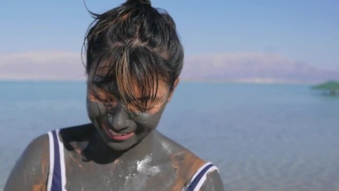 亚洲妇女在死海使用泥浆