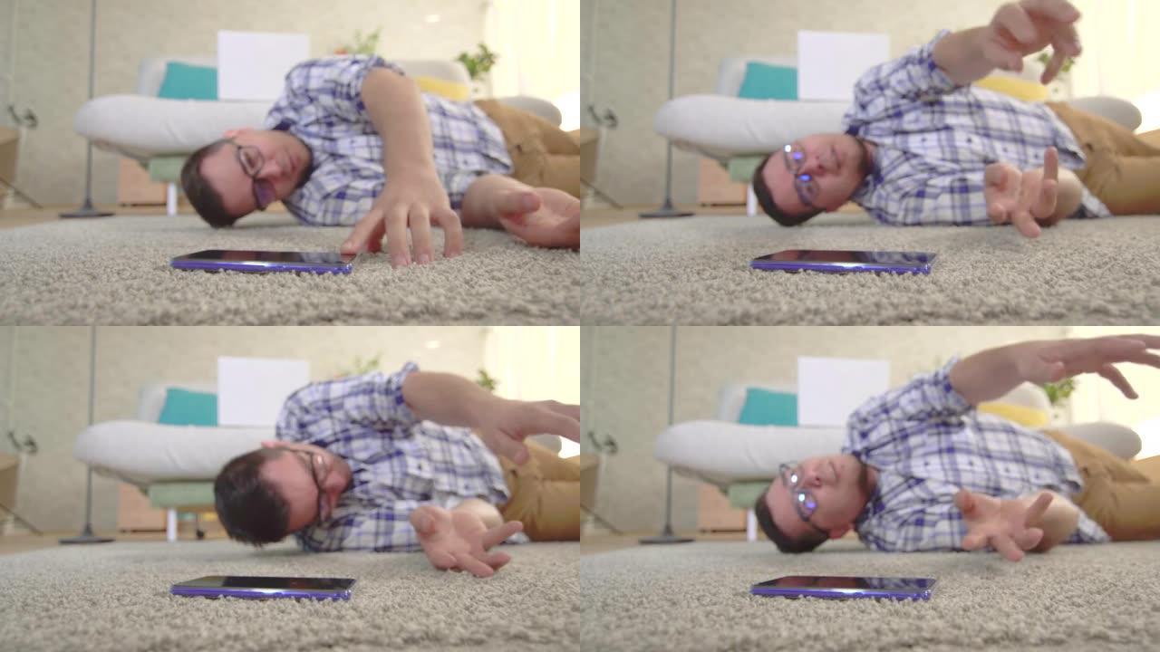 一个穿着衬衫和眼镜的年轻人癫痫发作，他试图到达躺在地板上的智能手机