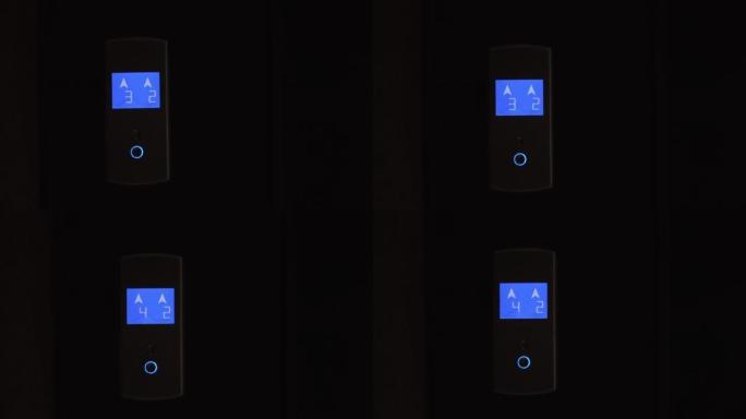 电梯圆形轻金属按钮的蓝色液晶显示器显示上下箭头、数字。