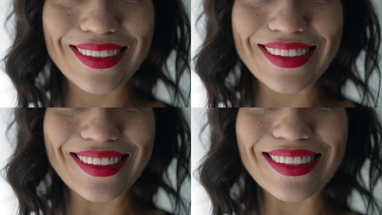 用红色唇膏微笑的女人的特写镜头。嘴巴感觉快乐的宏观特写