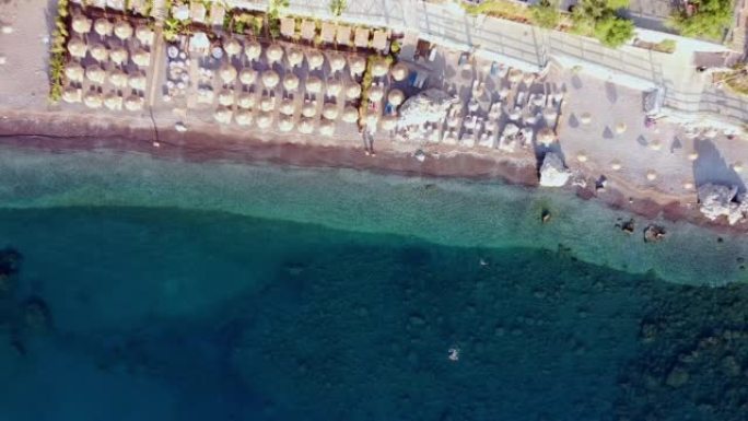 土耳其图伦克海滩的航拍视频。无人机在度假村的镜头上日出。海滩上的雨伞和日光浴浴床。