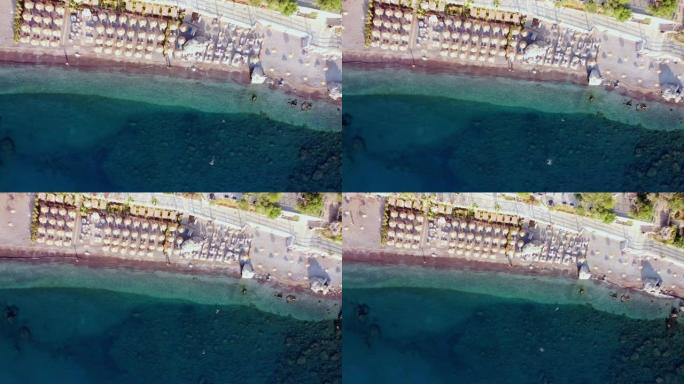 土耳其图伦克海滩的航拍视频。无人机在度假村的镜头上日出。海滩上的雨伞和日光浴浴床。
