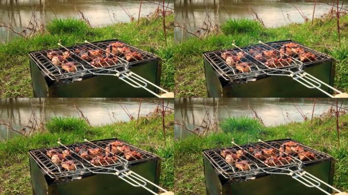 肉在河边的煤上的烤架上烤。