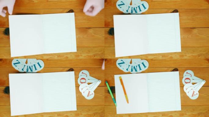 学校讲师在学前班教室的木桌上排成一排的笔记本，彩色笔和字母，用于学习拼写。复制文本空间。空白单页。顶