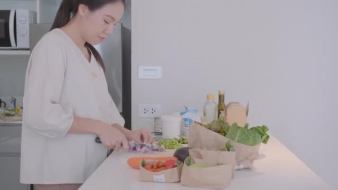 漂亮的节食女性在她的家庭厨房准备有机素食