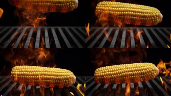 玉米芯落在烤架炉排上慢动作燃烧 -- 黑色背景上的烧烤