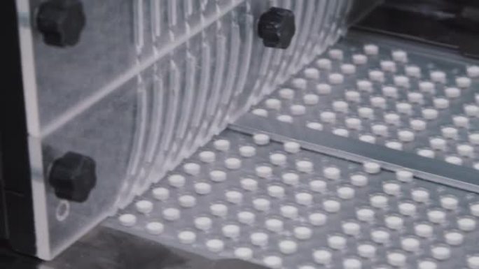 泡罩包装中的药丸沿着传送带移动。过程中自动化装配线的特写。制药生产线。