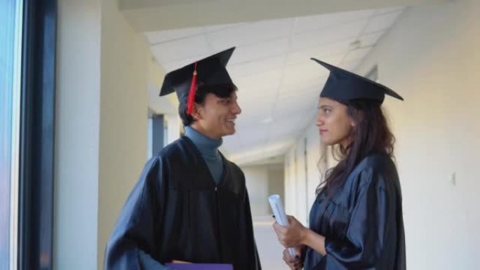 两名拥有文凭的印度学生毕业生在大学大楼交流