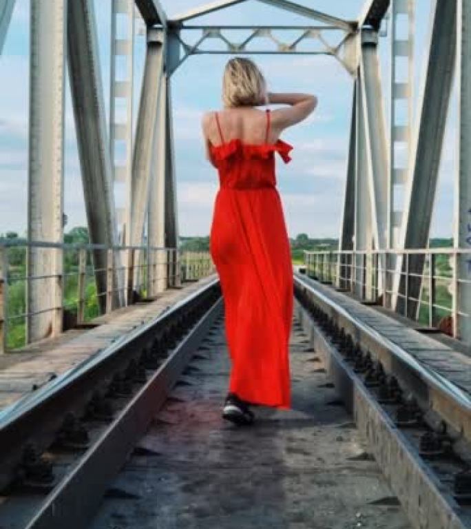 铁路上穿着红色连衣裙的女孩