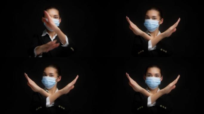 戴着医用口罩的严肃的亚洲妇女在X标志上交叉双臂说不