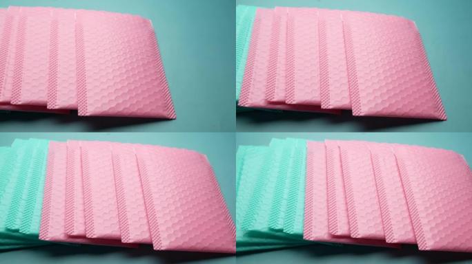 桌子上的粉色和绿色纸质气泡信封