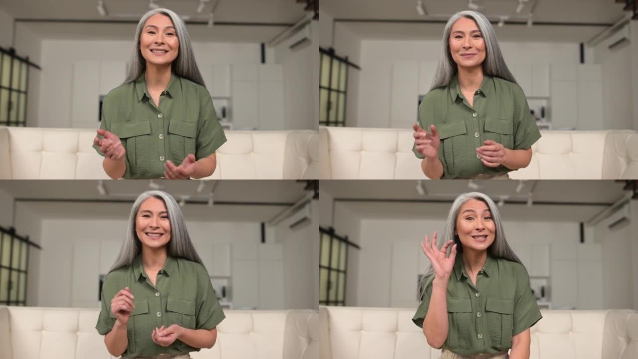微笑积极的中年亚洲妇女举行视频通话