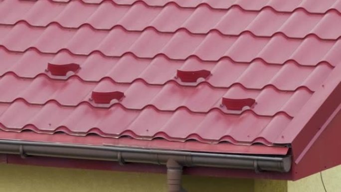 冬季在房屋屋顶上铺有钢瓦的防雪装置。建筑物的瓷砖覆盖物