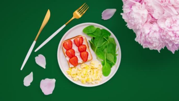 周末早午餐配奶油炒鸡蛋、吐司、草莓和菠菜。停止运动动画。
