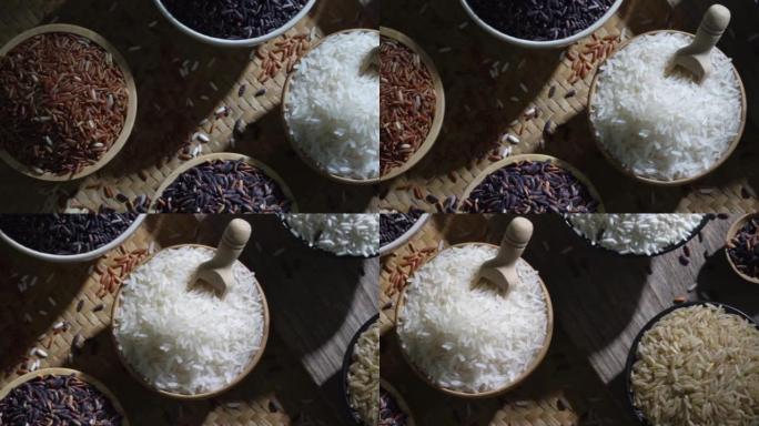 有机糙米和亚洲黑米饭，木桌碗中的茉莉白米饭，有机天然食品概念的未煮熟产品，顶视图