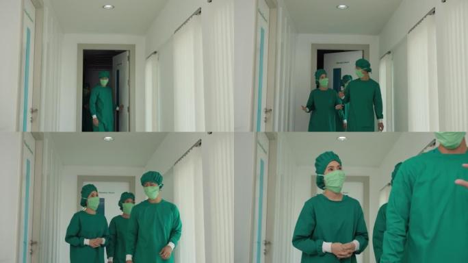 前视图外科医生和助手谈论走出手术室。