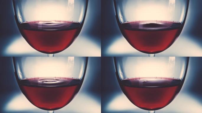 创意微距慢动作4k视频红酒在一杯和一滴落的酒。酒滴在玻璃杯中慢慢落下特写。在高速电影摄像机上拍摄。