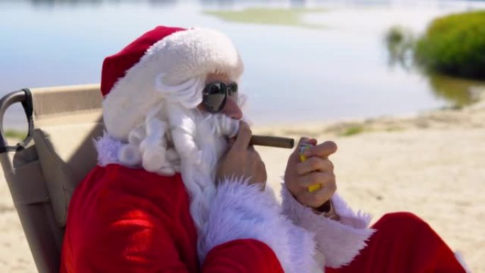 戴着墨镜的圣诞老人躺在热带海滩上的日光浴躺椅上抽雪茄