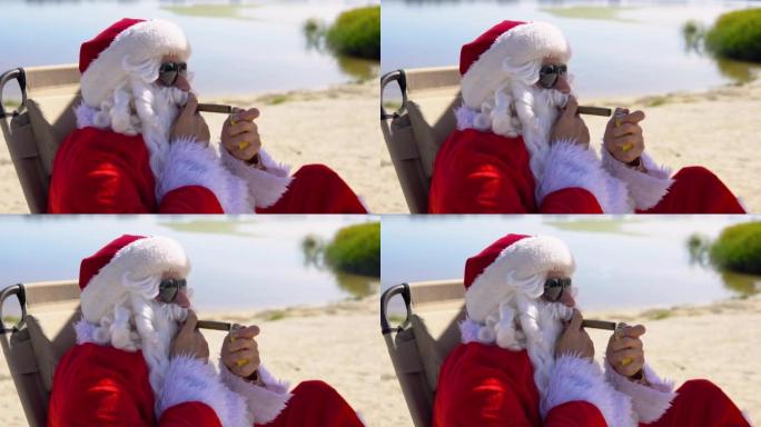 戴着墨镜的圣诞老人躺在热带海滩上的日光浴躺椅上抽雪茄