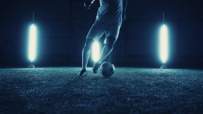 才华横溢的初级足球运动员在夜间独自训练，腿部特写镜头，自由式运球