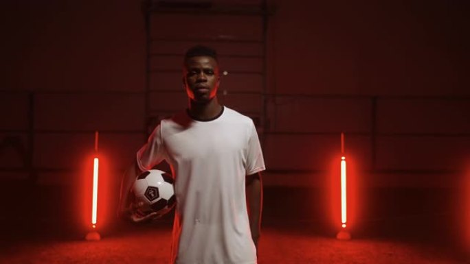 足球少年冠军，带艺术红灯的工作室里有球的非裔美国人肖像
