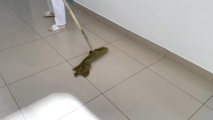 清洁工在医疗机构用拖把清洁地板。带慢动作的高质量4k镜头。