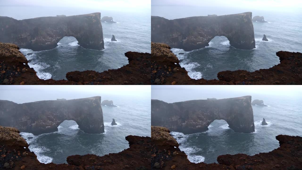 Dyrh ó laey半岛宏伟的天然岩石拱门的景色，位于冰岛v í m ý rdal附近的环路上，大