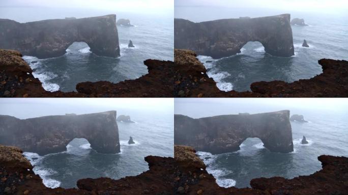 Dyrh ó laey半岛宏伟的天然岩石拱门的景色，位于冰岛v í m ý rdal附近的环路上，大