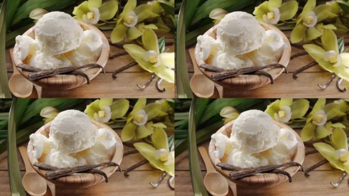 香草冰淇淋球放在碗里，里面放着香草兰花和香草棒，放在旁边的老式木桌上，后面放着绿叶。
