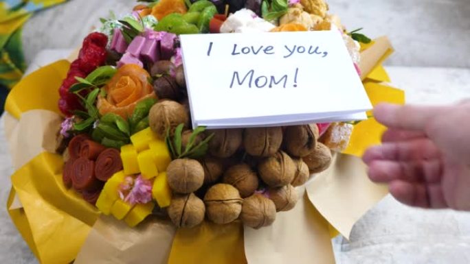 甜蜜的花束礼物和卡片，上面写着我爱你妈妈。母亲节假期概念。儿子表达对妈妈的爱。致妈妈的感谢信
