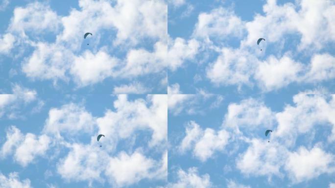 蓝天上云层前降落伞的特写镜头。冒险爱好者在天空中滑翔伞。印度喜马偕尔邦马纳利的探险活动。喜欢滑翔伞的