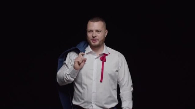 一个穿着白色衬衫的性感男人，系着一条未系扣子的红色领带，肩膀上系着一件夹克，笑得很真诚。