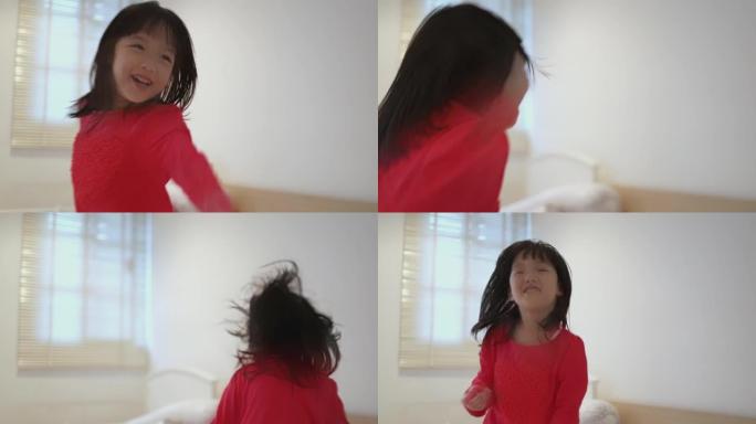 4k视频慢动作亚洲妈妈和小孩在卧室的床上跳舞和跳跃。
