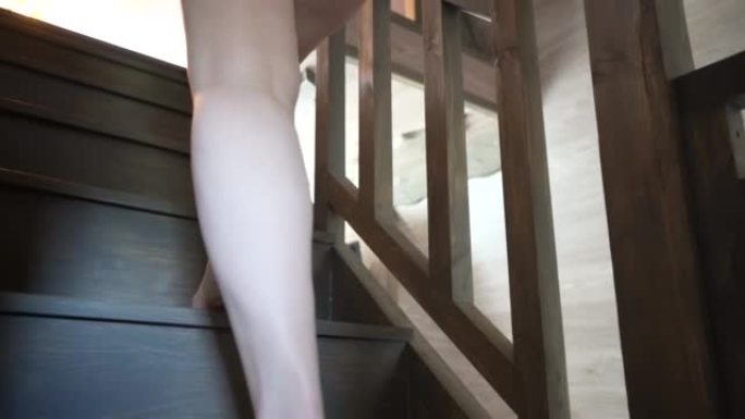 一个女孩在乡间别墅的木制楼梯上赤脚的特写