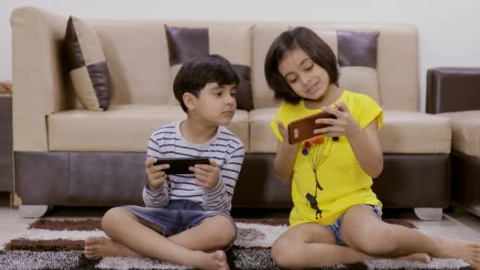 兄弟姐妹在智能手机上玩游戏，姐姐在屏幕上显示