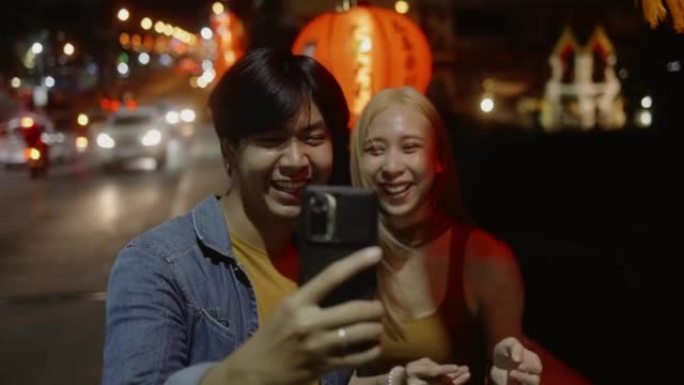 年轻的亚洲夫妇在农历新年元宵节通过电话在社交网络上进行视频直播。