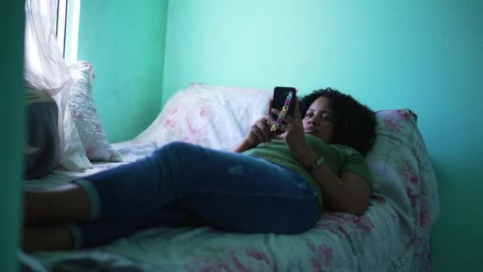偷情的女孩躺在家里的床上看手机