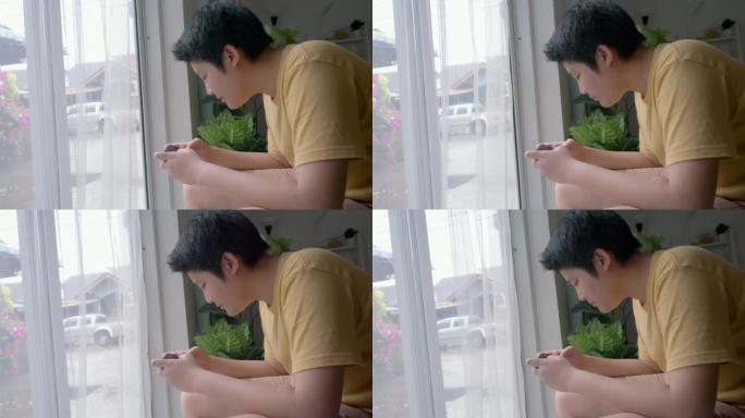 亚洲男孩在家附近玩手机游戏，生活方式概念。