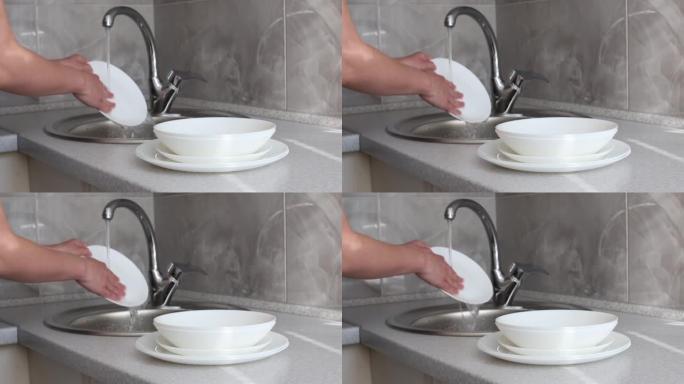 用手在厨房的水槽里洗碗特写