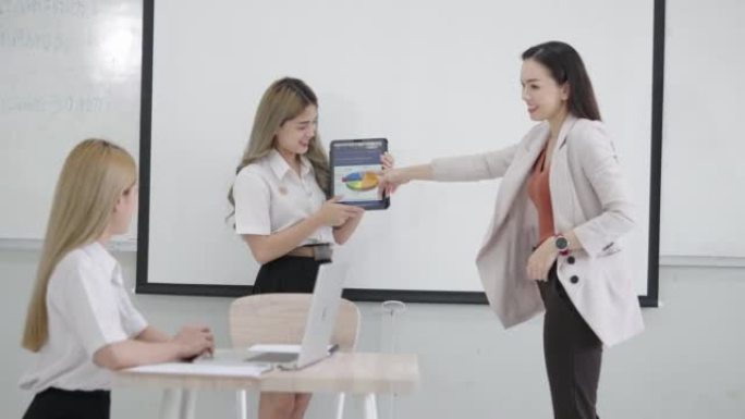 团体亚洲女学生大学在课堂上与女老师教授一起解释和介绍