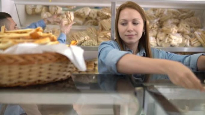 女面包店员工的肖像在柜台上摆放了一个装有咸奶酪饼干的篮子