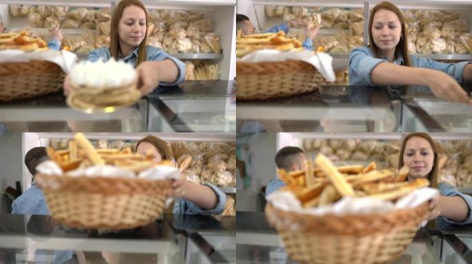 女面包店员工的肖像在柜台上摆放了一个装有咸奶酪饼干的篮子