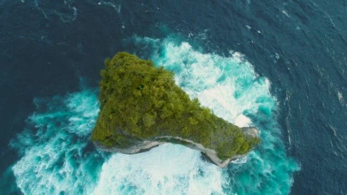 一个热带树木覆盖的小岛的航拍画面，中间有拱门。4K